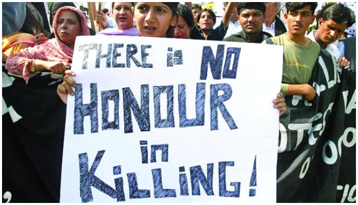 A woman holds banner against honour killing at a protest in Pakistan. — Reuters/ file