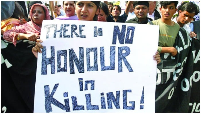 A woman holds banner against honour killing at a protest in Pakistan. — Reuters/ file