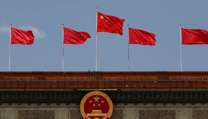 A Chinese flag flutters above the Chinese national emblem at the Great Hall of the People after the opening session of the National Peoples Congress (NPC) in Beijing, China May 22, 2020. — Reuters/File