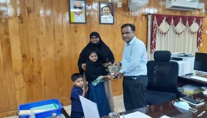 Tamil Nadu girl hands over her savings to  district collector Shankar Lal Kumawat to be donated to Sri Lanka.—Twitter/@kavinthans