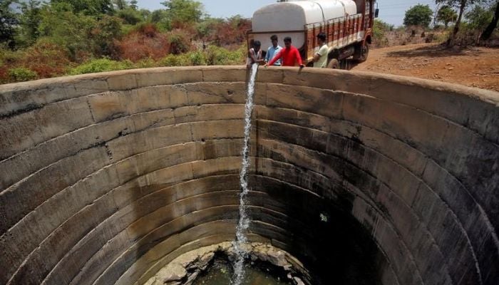 A dried-up well is refilled with water from a water tanker in Thane district in the western state of Maharashtra, India, May 30, 2019.—Reuters