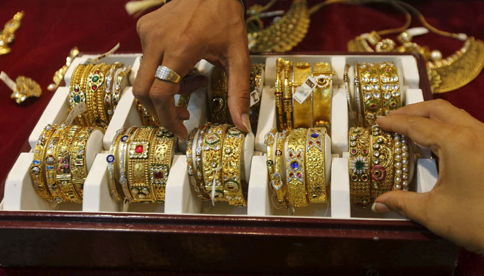 A salesman helps a customer (R) to select gold bangles at a jewellry showroom in Mumbai, India, on May 21, 2015. — Reuters/File