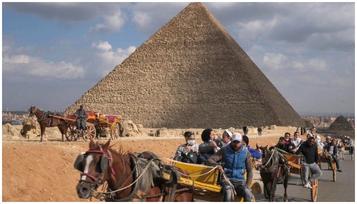 Tourists taking a horse-cart ride outside the pyramids of Giza in Egypt. — AFP