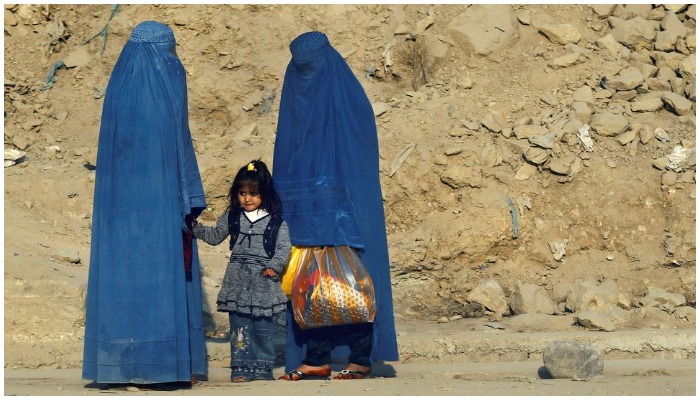 Afghan women clad in burkas wait for transportation on a road in Kabul November 5, 2012. — Reuters/ file