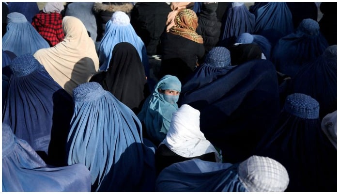 A girl sits in front of a bakery in the crowd with Afghan women waiting to receive bread in Kabul, Afghanistan, January 31, 2022. — Reuters/ file