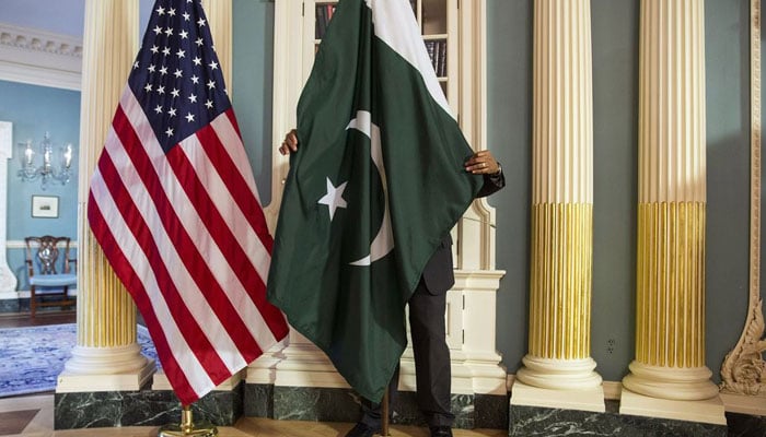A State Department contractor adjust a Pakistan national flag before a meeting between US Secretary of State John Kerry and Pakistan's Interior Minister Chaudhry Nisar Ali Khan on the sidelines of the White House Summit on Countering Violent Extremism at the State Department in Washington February 19, 2015. — Reuters/File