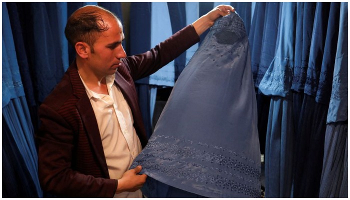 An Afghan salesman displays a burqa in his shop at a marketplace in Kabul, Afghanistan, on May 10, 2022. —Reuters