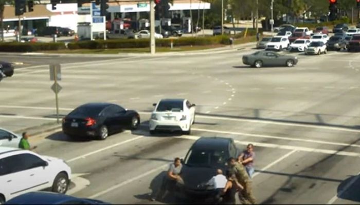 People stop car to save woman suffering medical episode. — Screengrab via YouTube/Boynton Beach Police