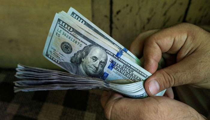 A currency dealer counting $100 notes. — Reuters/File