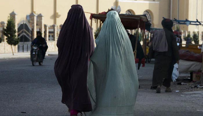 Burqa-clad womenwalk along a street in Kandahar on May 7, 2022. —AFP