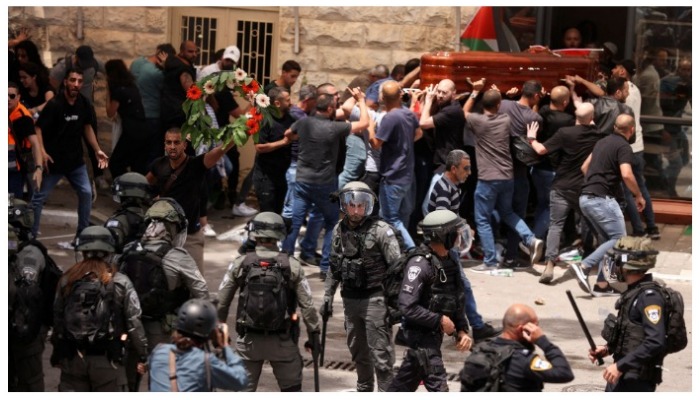 Family and friends carry the coffin of Al Jazeera reporter Shireen Abu Akleh, who was killed during an Israeli raid in Jenin in the occupied West Bank, next to Israeli security forces, during her funeral in Jerusalem, May 13, 2022. —  Reuters/Ammar Awad