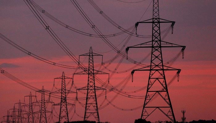 The sun rises behind electricity pylons near Chester, northern England October 24, 2011. — Reuters