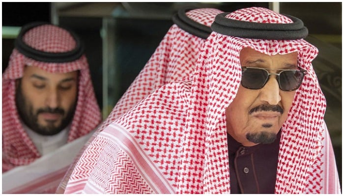 Saudi Crown Prince Mohammed bin Salman is seen in the background of a closeup of King Salman leaving hospital on May 16. — SPA/File
