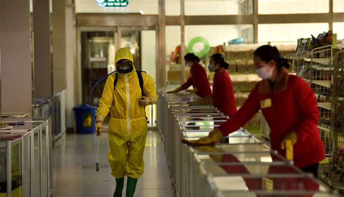 In this file photo taken on March 18, 2022 employees spray disinfectant and wipe surfaces as part of preventative measures against the Covid-19 coronavirus in Pyongyan. Photo— KIM Won Jin / AFP