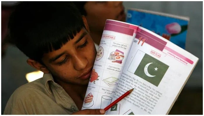 A boy points pencil on the text to read. — Reuters