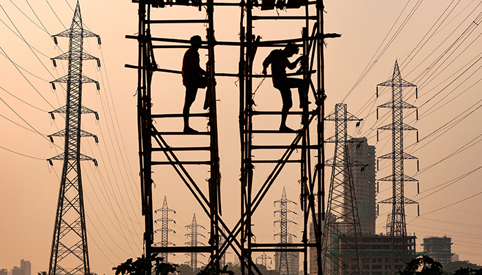 مزدور 13 اکتوبر 2021 کو ممبئی، انڈیا میں بجلی کے کھمبوں کے ساتھ کام کر رہے ہیں۔ - رائٹرز
