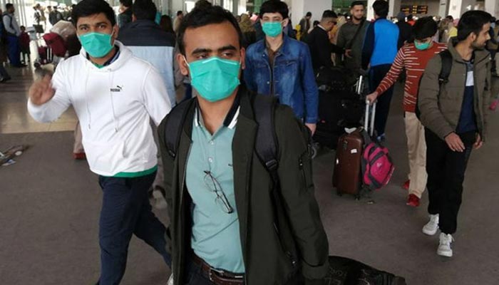 Pakistani students wearing protective face masks come out upon their arrival from China at the Islamabad International Airport. — AFP/File