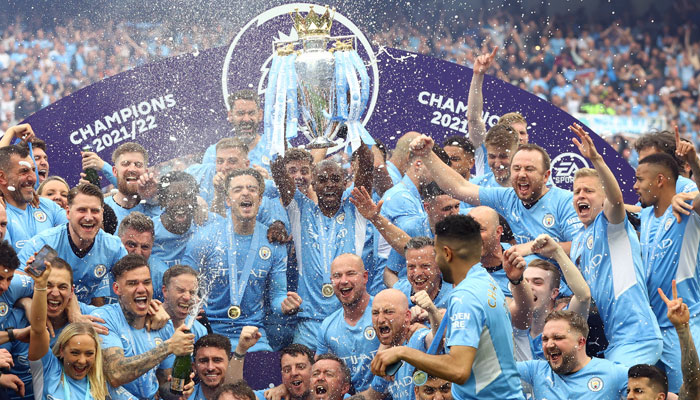 Manchester Citys Fernandinho lifts the trophy as he celebrates with teammates after winning the Premier League. — Reuters