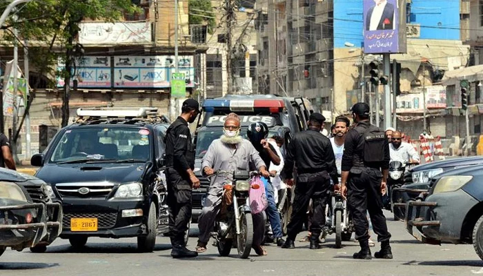 Police officials checking identity of people at Saddar. — APP/M Saeed Qureshi