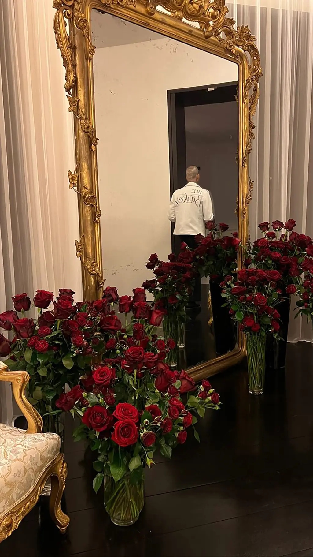 Dozens of other red roses lined a gold mirror in their room