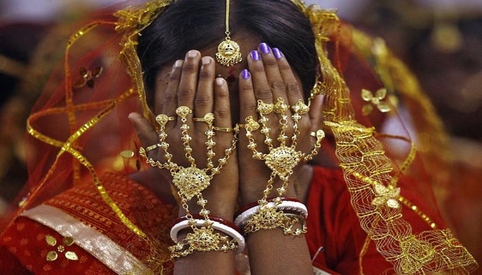 A bride covers her face as she waits to take her wedding vow at a mass marriage ceremony at Bahirkhand village, Kolkata February 8, 2015.—Reuters