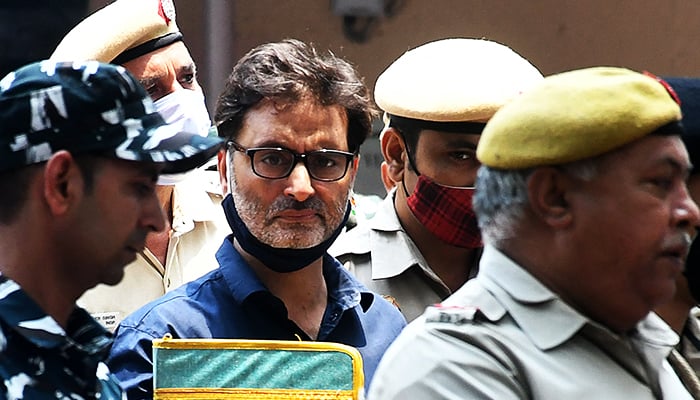 Yasin Malik, chairman of Jammu Kashmir Liberation Front (JKLF), a separatist party, is escorted by Indian police officers at court premises in New Delhi, India, on May 25, 2022. — Reuters