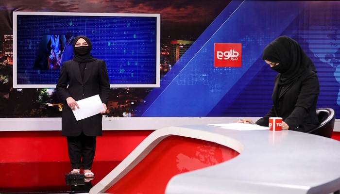 Female presenters for Tolo News, Sonia Niazi and Khatereh Ahmadi, while covering their face, work in a newsroom at Tolo TV station in Kabul, Afghanistan, May 22, 2022.—Reuters