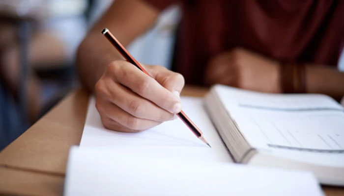 Representative image of a person writing on paper using a pencil. — Unsplash