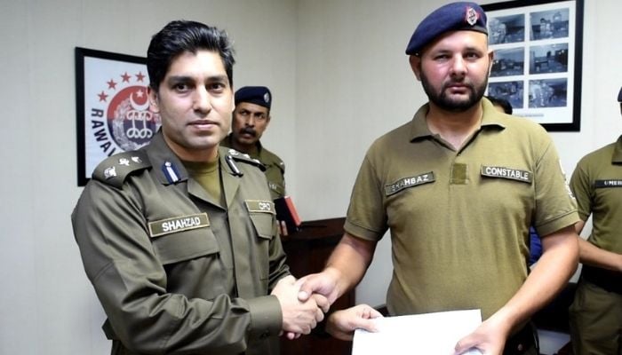 Chief Police Officer Shahzad Nadeem Bukhari awarding an appreciation certificate and a cash incentive to Constable Mohammad Shahbaz — Twitter/@RwpPolice