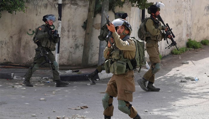 Israeli soldiers take positions during clashes with Palestinian in village of Azzun in the north of the occupied West Bank . Photo by JAAFAR ASHTIYEH / AFP