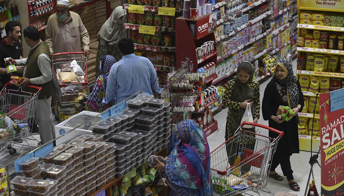 People buy grocery items at a store in Peshawar. Photo: AFP/file