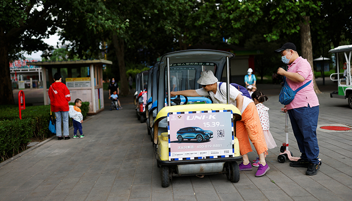 A woman wipes an electric car before using it at Sun Park on the day of its reopening after the government eased some of the restrictions, amid the coronavirus disease (COVID-19) outbreak in Beijing, China May 29, 2022. — Reuters