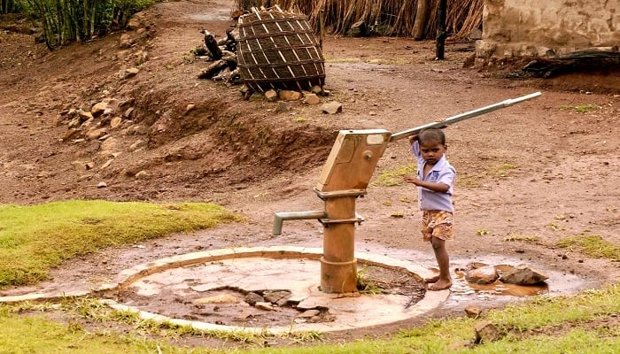 (representational) a child stands near a well inBhor Rice Village.—Unsplash/bradford zak