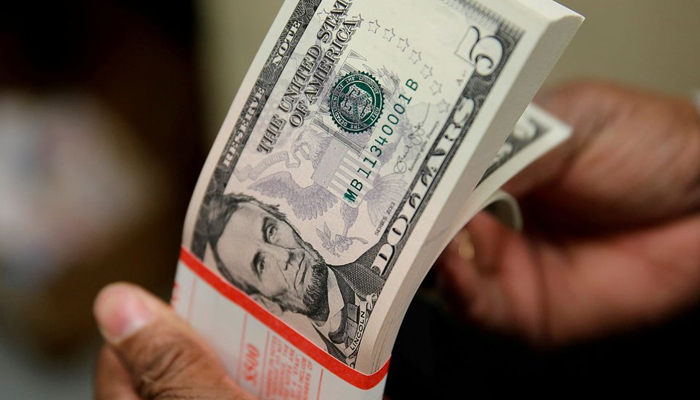 A person holds a stack of dollars. — Reuters/File