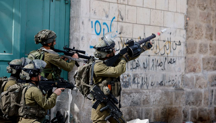 An Israeli soldier uses a weapon amid clashes with Palestinian protesters, in Hebron, in the Israeli- occupied West Bank on April 1, 2022. — Reuters