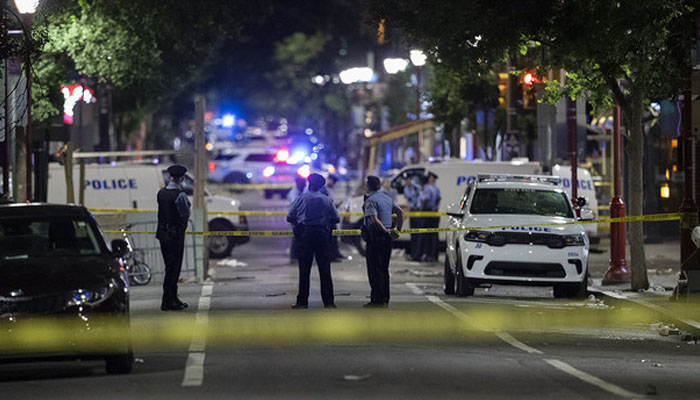 Philadelphia Police officers and detectives look over evidence at the scene of a shooting in Philadelphia on June 5. Photo— Charles Fox/The Philadelphia Inquirer via AP