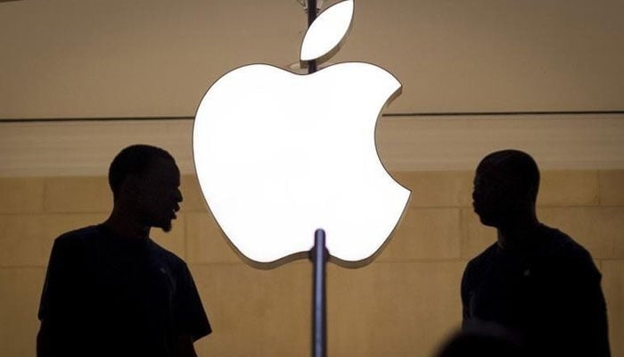 Two persons are silhouetted against a logo sign of the Apple Store in the Grand Central Terminal in the Manhattan borough of New York City, New York, US. — Reuters/File