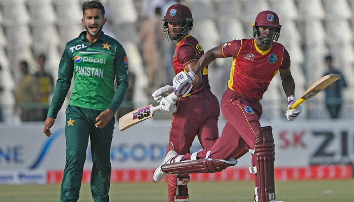 Shamarh Brooks (R) and Shai Hope (C) run between the wicket as Hasan Ali watches during the first ODI between Pakistan and West Indies at the Multan Cricket Stadium. — AFP