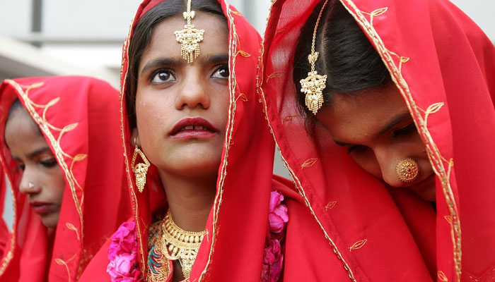 Pakistani brides sit during a mass wedding ceremony in Karachi. — Reuters