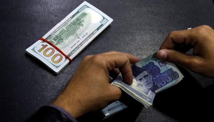 A currency trader counts Pakistani rupee notes as he prepares an exchange of dollars in Islamabad, Pakistan December 11, 2017.—Reuters