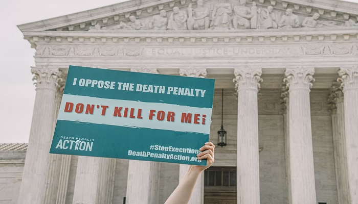 John Quinn of Democrats for Life of America holds a sign in front of the Supreme Court in Washington, DC, calling on the justices to choose mercy for Dzhokhar Tsarnaev, the Boston Marathon Bomber.—Unsplash/mcoswalt