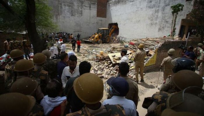 In Prayagraj, India, on June 12, 2022, a bulldozer demolishes the home of a Muslim man accused of involvement in last weeks rioting over comments made by BJP members regarding the Prophet Mohammed. The house was illegally built, say authorities — Reuters