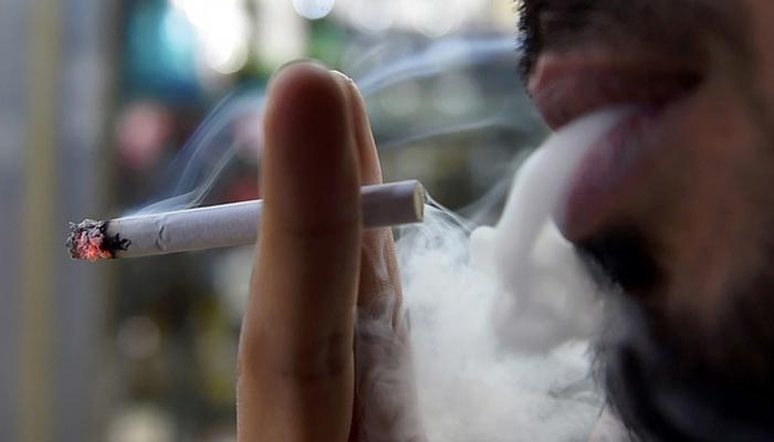 A man smokes outside a tobacco shop in the Saudi capital Riyadh late on June 11, 2017. — AFP/File