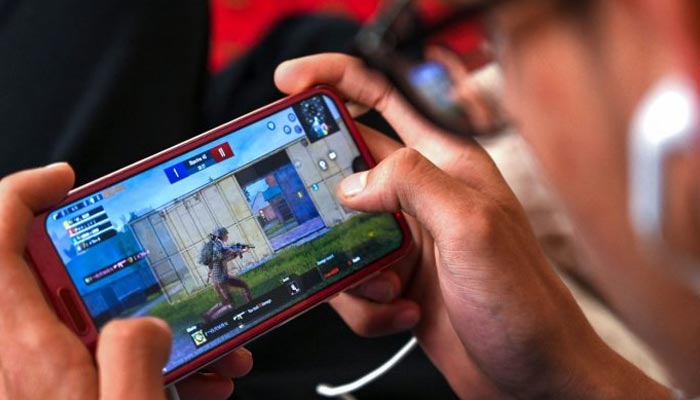 The picture shows a person playing PUBG on a mobile phone. — AFP/File