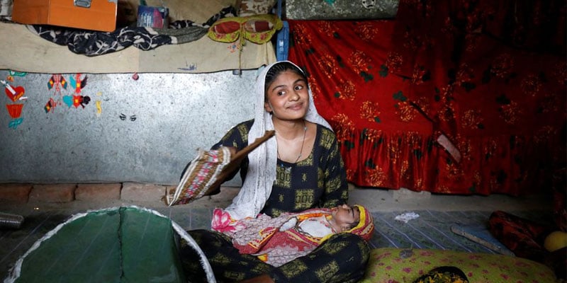 Farmer Waderi, 17, fans her one-month-old son Amar Kumar during a heatwave, at home, on the outskirts of Jacobabad, Pakistan, May 17, 2022. Photo: Reuters