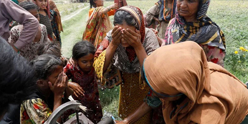 Women and children wash themselves after work at a muskmelon farm, during a heatwave, at a hand pump on the outskirts of Jacobabad, Pakistan, May 17, 2022. Photo: Reuters