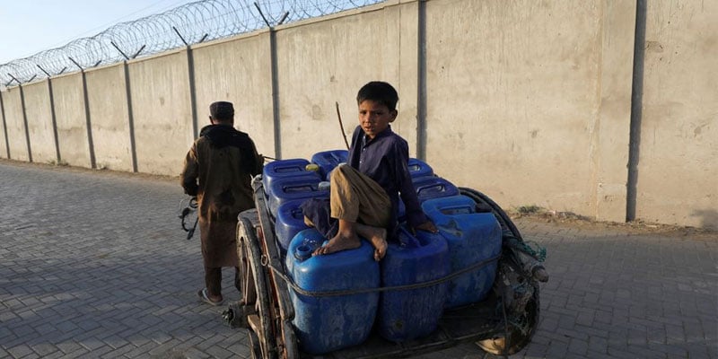 A man pulls a donkey cart as a boy sits on jerrycans, filled with water from a private pump, to sell them door-to-door, during a heatwave at residential area in Jacobabad, Pakistan, May 13, 2022. Photo: Reuters