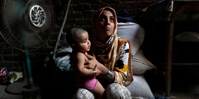 Razia, 25, and her six-month-old daughter Tamanna, sit in front of a fan to cool off during a heatwave, in Jacobabad, Pakistan, May 15, 2022. Photo: Reuters