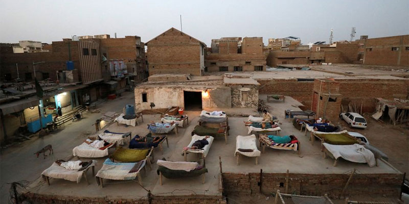 جیکب آباد، پاکستان، 15 مئی 2022 میں ایک چھت پر صبح سویرے ہیٹ ویو کے دوران مرد چارپائی رسی کے بستروں پر سو رہے ہیں۔ تصویر: رائٹرز