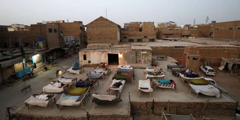 Men sleep on charpoy rope beds, early in the morning during a heatwave, on a roof in Jacobabad, Pakistan, May 15, 2022. Photo: Reuters